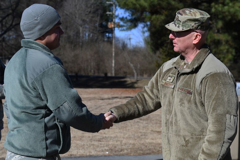 Two men shake hands.