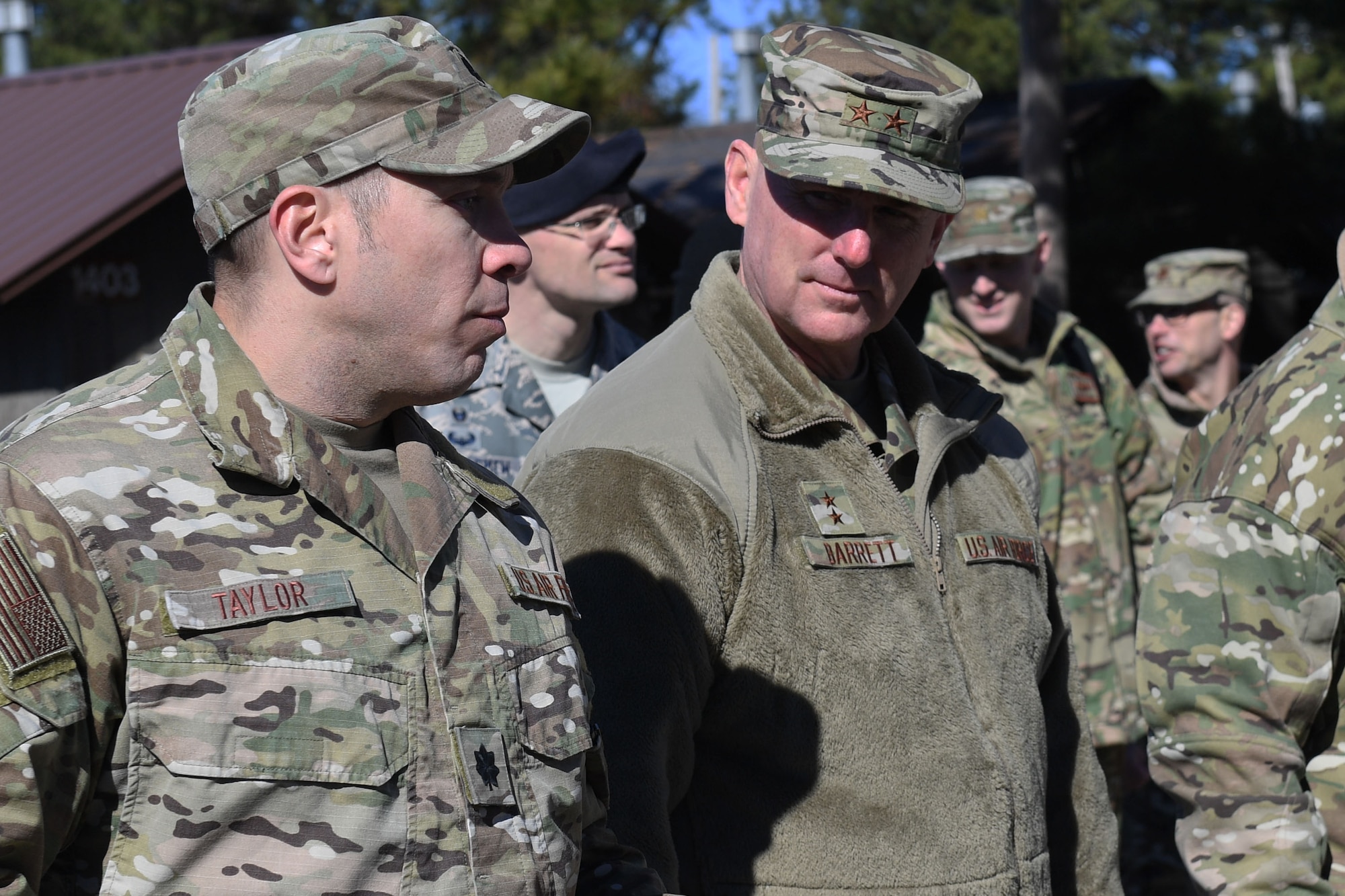 Two men look to each other and talk.