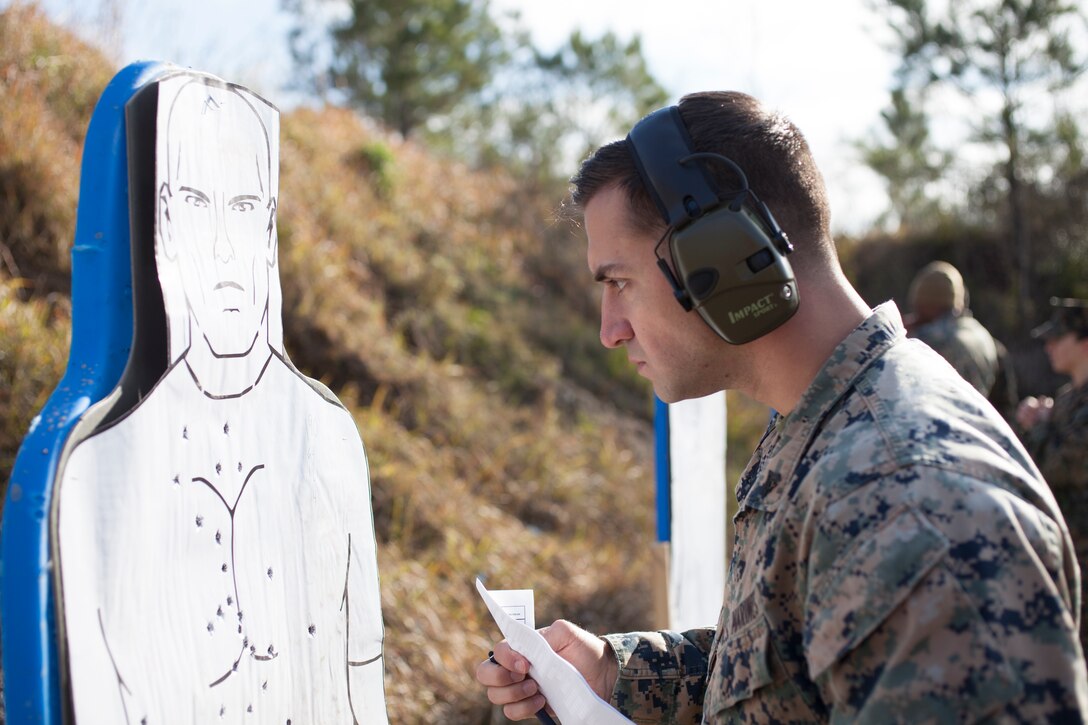 Cpl. Benjamin Crochet, a combat marksmanship trainer with Headquarters Battalion, Marine Forces Reserve, calculates the pistol qualification score for a Marine during the Combat Pistol Program, at Camp Villere, La., Jan. 24, 2019.