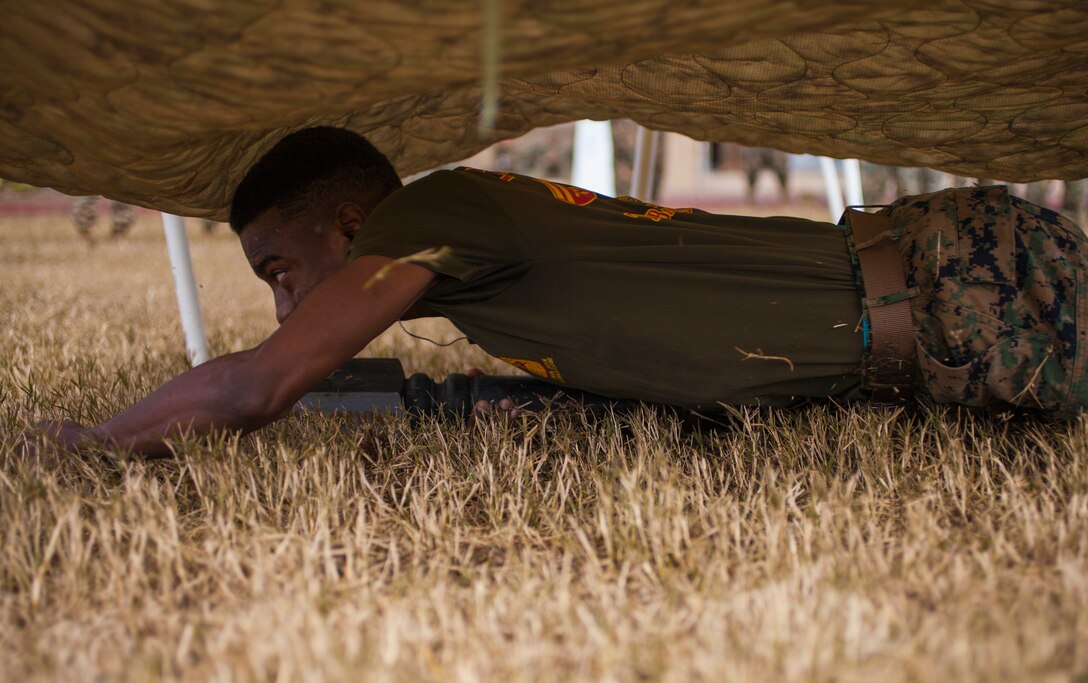 Cpl. Shaconey White, sourcing cell noncommissioned officer in charge with Marine Forces Reserve G-1 Operations, low crawls under a platform during the MARFORRES Log Race Competition at Marine Corps Support Facility New Orleans, Jan. 17, 2019
