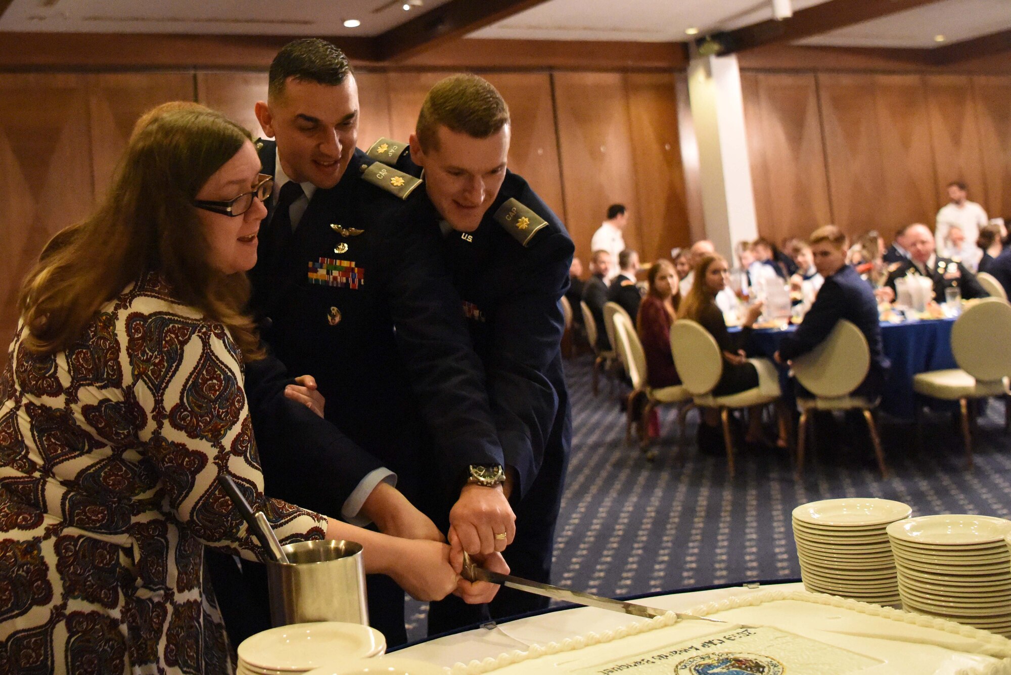 Distinguished guests cut a cake with a ceremonial sword at a Civil Air Patrol banquet at the Officer's Club on Ramstein Air Base, Germany, Feb. 2, 2019. CAP provides a unique opportunity for youth to experience life in military, teaching discipline and leadership to the next generation of possible Airmen. (U.S. Air Force photo by Airman 1st Class Milton Hamilton)