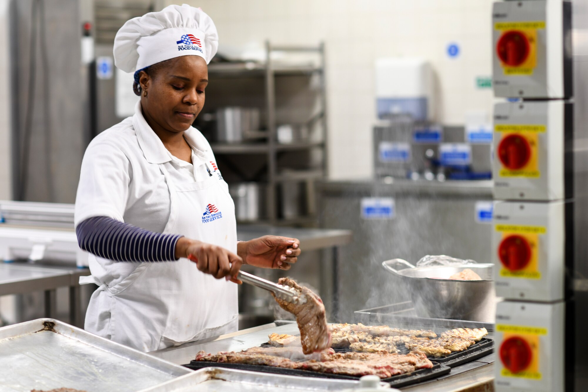 Stha Moyo, a 48th Force Support Squadron chef, prepares steaks to be served for dinner at the Knight’s Table dining facility on Royal Air Force Lakenheath, England, Jan. 31, 2019. The Knight’s Table provides four meals daily Monday through Friday, and two meals on weekends and holidays. (U.S. Air Force photo by Senior Airman Malcolm Mayfield)