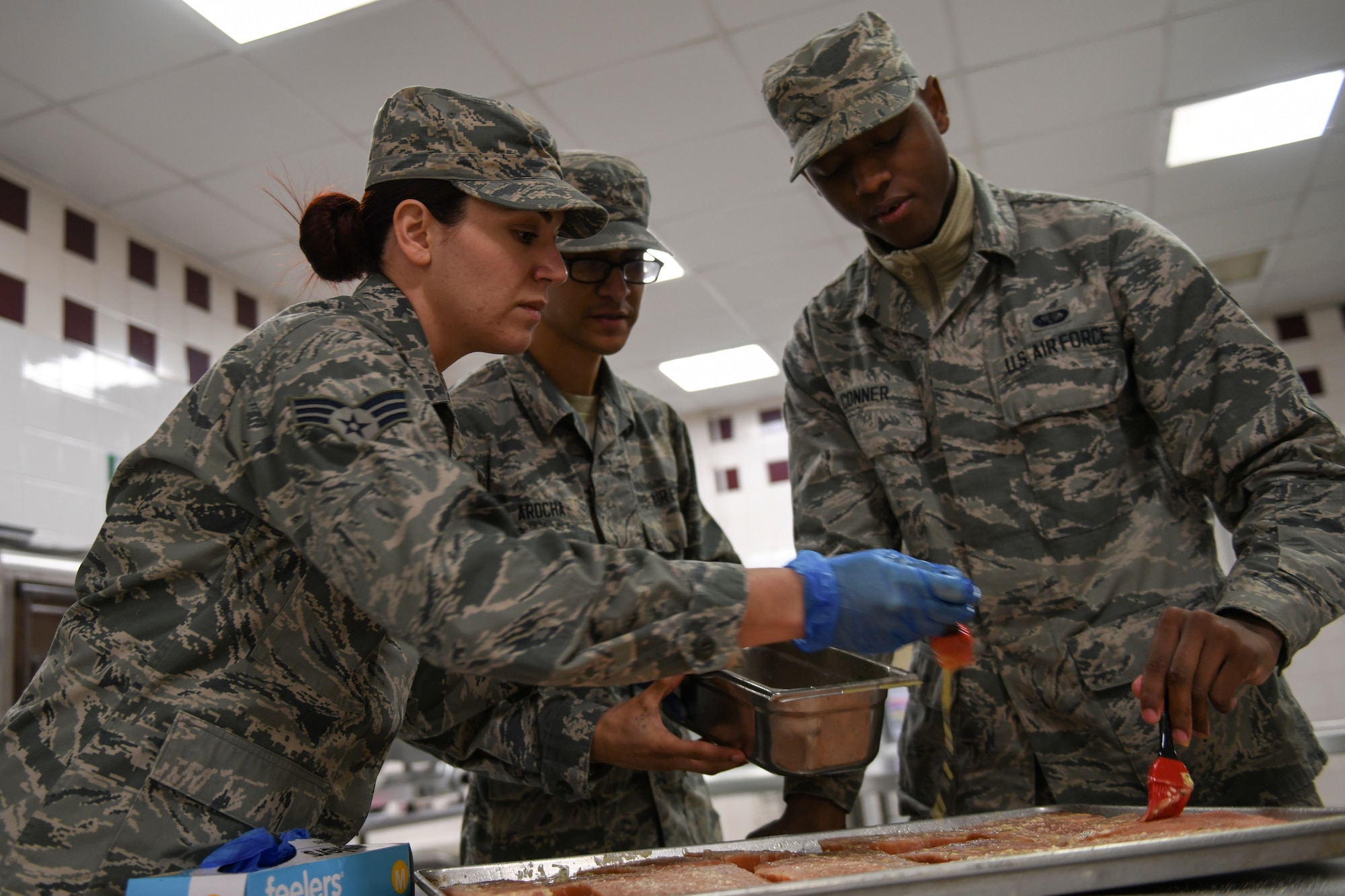 Chefs assigned to the 48th Force Support Squadron marinate fish to be served for dinner at the Knight’s Table dining facility on Royal Air Force Lakenheath, England, Jan. 31, 2019. The facility produces more than 700 meals each day. (U.S. Air Force photo by Senior Airman Malcolm Mayfield)