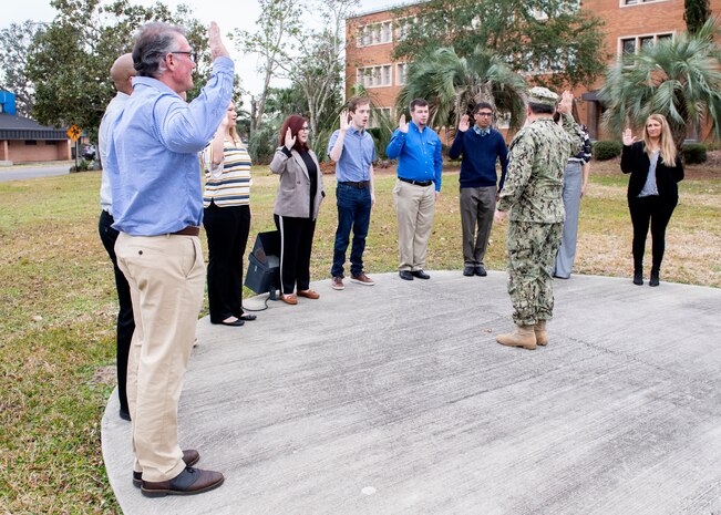 Naval Surface Warfare Center Panama City Division Commanding Officer Capt. Aaron Peters administers the oath of office to 10 newly hired federal civil service employees at the flagpole Feb. 4, 2019. U.S. Navy photos by Eddie Green