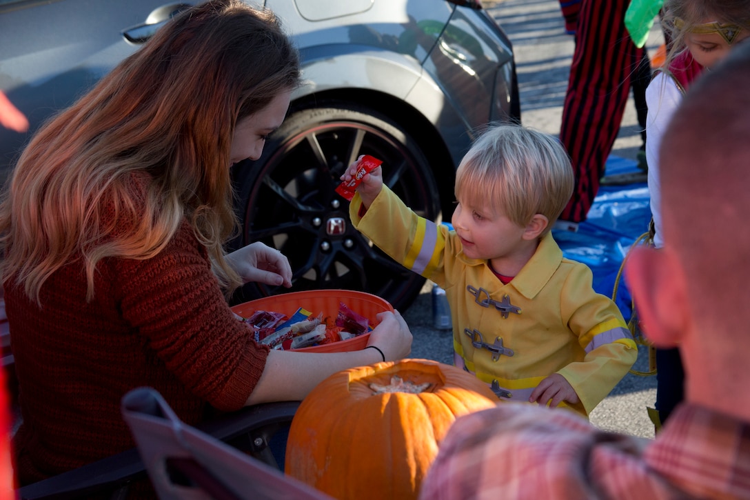 Myles, 2, gets candy during Marine Corps Community Services’ annual Trunk or Treat at Marine Corps Air Station Cherry Point, North Carolina, Oct. 30, 2018. Nearly 100 vehicles were decked out with their spookiest designs displayed to terrify patrons while the car owners handed out candy to the tinier trick-or-treaters of the families. Activities available for families also included touch-the-truck displays, ring toss, a potato sack race, bowling, high striker strength tester, and a Halloween-themed movie. (U.S. Marine Corps photo by Lance Cpl. Alexandra Santos Arambulo)
