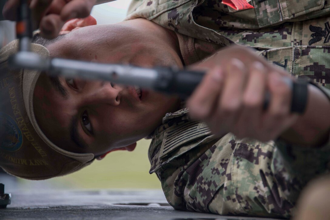 U.S. Navy Petty Officer 2nd Class Sergio Valasquez, a mineman with Navy Munitions Command Atlantic Unit Charleston tightens a bolt on an inert underwater mine at Barksdale Air Force Base, Louisiana, Jan. 30, 2019.  The mines are prepared by Navy personnel, but loaded onto a B-52 Stratofortress by Reserve Citizen Airmen.  The B-52 can lay mines as part of its maritime capabilities. (U.S. Air Force photo by Master Sgt. Ted Daigle)
