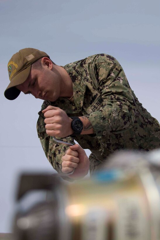 U.S. Navy Petty Officer Dylan Scott, a mineman with Navy Munitions Command Atlantic Unit Charleston makes final adjustments to an inert naval mine at Barksdale Air Force Base, Louisiana, Jan. 30, 2019.   The mines will be laid by a B-52 Stratofortress operating out of Barksdale AFB.  (U.S. Air Force photo by Master Sgt. Ted Daigle)