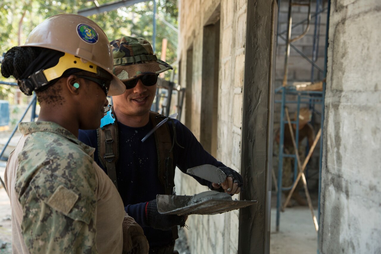 Two people applying cement