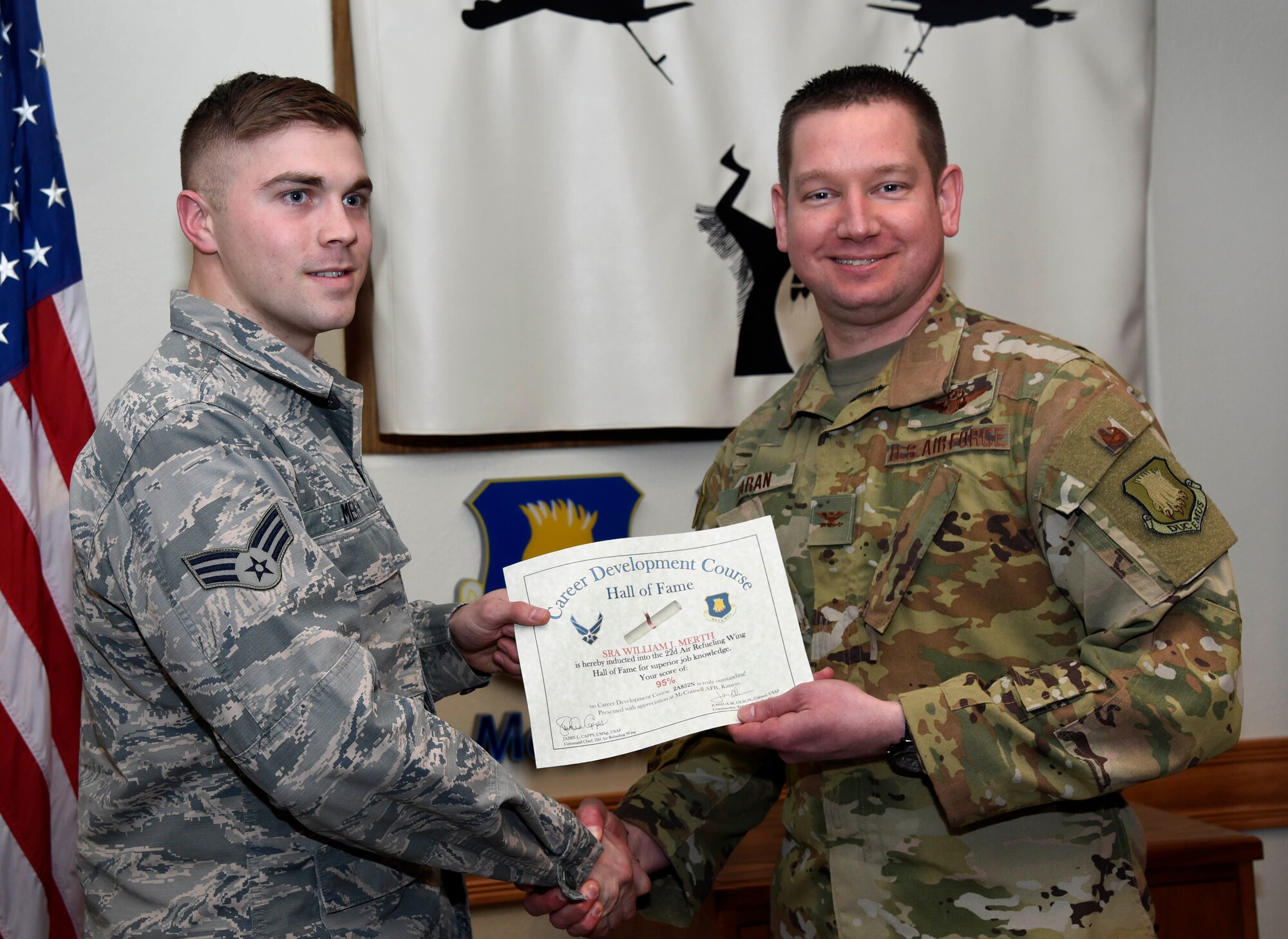 Senior Airman William Merth, 22nd Aircraft Maintenance Squadron integrated flight control system apprentice, left, is recognized by Col. Mark Baran, 22nd Air Refueling Wing vice commander, for earning a score of 95 percent on his Career Development Course Feb. 5, 2019, at McConnell Air Force Base, Kan. CDCs help enlisted personnel complete the specialty knowledge portion of on-the-job training for their specific career fields.
