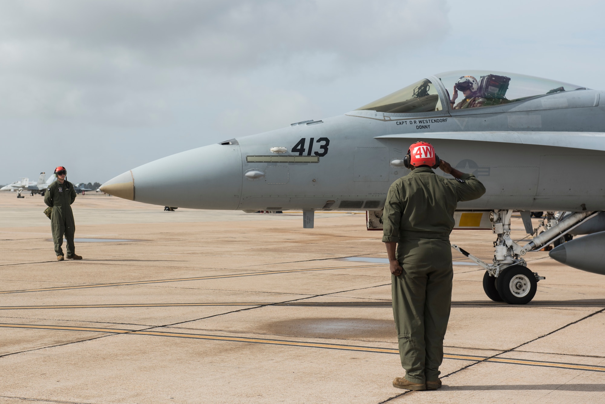 U.S. Marine Corps Sgt. Ben Liberal, 323d Marine Fighter Attack Squadron ordinance team leader, salutes an F/A-18C Hornet pilot prior to takeoff during joint exercise Winter Fury at Marine Air Station Miramar, San Diego, Calif., Jan. 18, 2019. Winter Fury involved both Marine F/A-18C Hornets, and Navy F-35C Lightning II’s, partnering with Air Force F-22 Raptors to perform air-to-air combat, while protecting ground assets.