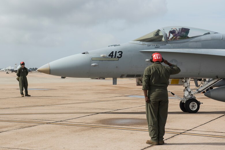 U.S. Marine Corps Sgt. Ben Liberal, 323d Marine Fighter Attack Squadron ordinance team leader, salutes an F/A-18C Hornet pilot prior to takeoff during joint exercise Winter Fury at Marine Air Station Miramar, San Diego, Calif., Jan. 18, 2019. Winter Fury involved both Marine F/A-18C Hornets, and Navy F-35C Lightning II’s, partnering with Air Force F-22 Raptors to perform air-to-air combat, while protecting ground assets.