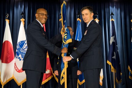 U.S. Air Force Gen. CQ Brown, Jr., commander, Pacific Air Forces, passes the 5th Air Force guidon to the new 5th Air Force commander, U.S. Air Force Lt. Gen. Kevin B. Schneider, during a change of command ceremony at Yokota Air Base, Japan, Feb. 5, 2019. The passing of the guidon marks the beginning of Schneider's tour as the commander 5th Air Force. (U.S. Air Force photo by Senior Airman Donald Hudson)