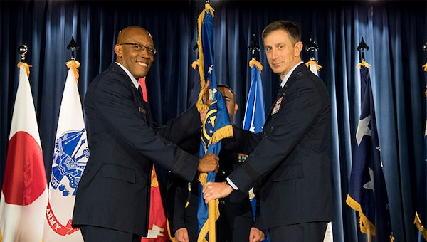 U.S. Air Force Gen. CQ Brown, Jr., commander, Pacific Air Forces, passes the 5th Air Force guidon to the new 5th Air Force commander, U.S. Air Force Lt. Gen. Kevin B. Schneider, during a change of command ceremony at Yokota Air Base, Japan, Feb. 5, 2019. The passing of the guidon marks the beginning of Schneider's tour as the commander 5th Air Force. (U.S. Air Force photo by Senior Airman Donald Hudson)