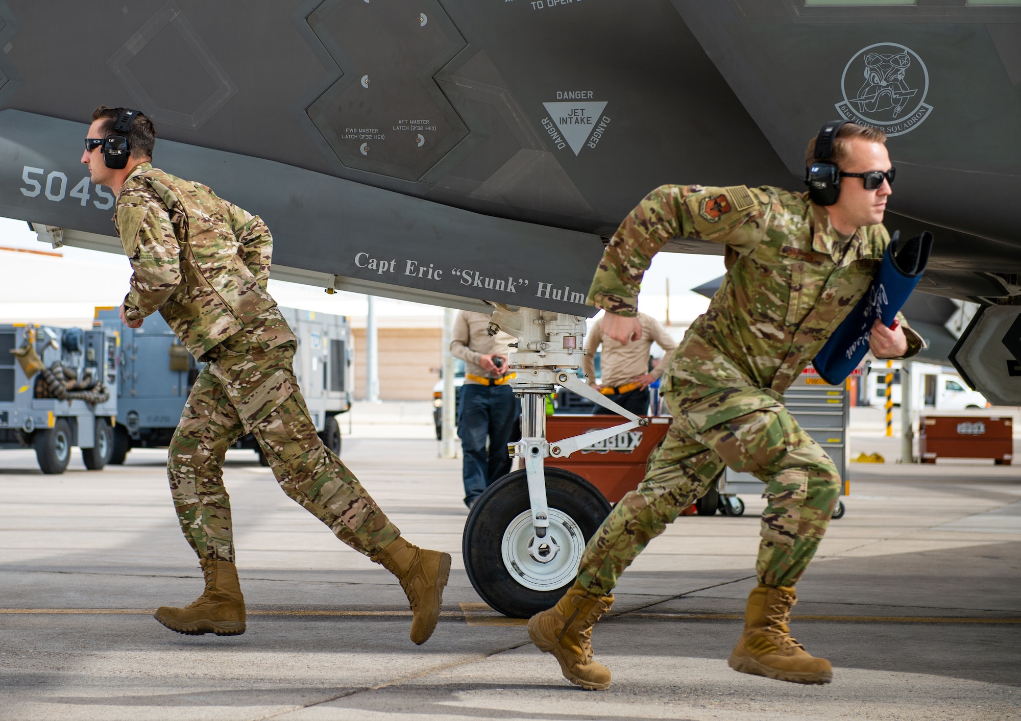 Staff Sgt. Paul Ogletree, F-35A Lighting II Demonstration Team dedicated crew chief, (left) and Tech. Sgt. Michael Couture, F-35 Demo Team lead (right) sprint to their positions during a ground performance Jan. 31, 2019, at Luke Air Force Base, Ariz. The team’s newly developed ground performance features sharp, fast paced movements which highlight the pride and professionalism of the team and U.S Air Force. (U.S. Air Force photo by Senior Airman Alexander Cook)