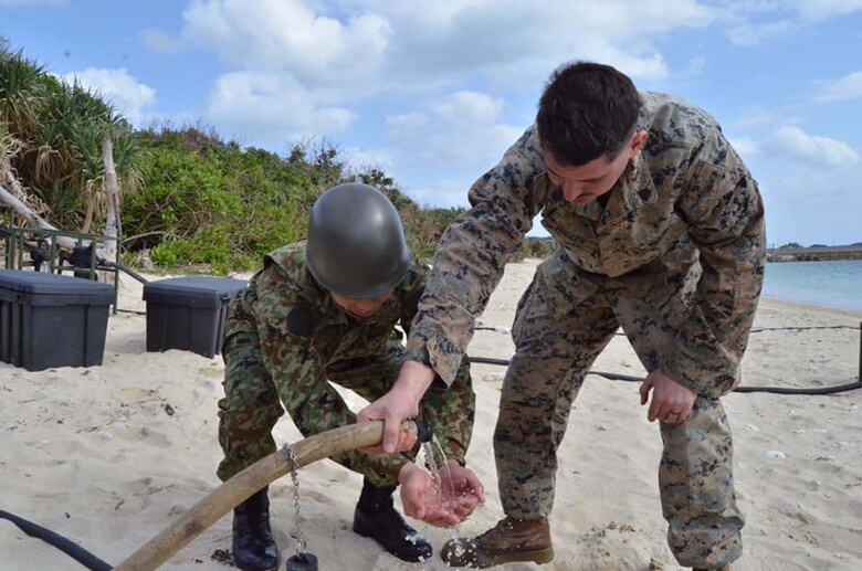 海兵隊員が陸自隊員に浄化水を見せています。