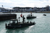 Combat engineers navigate across the water in bridge erection boats (BEBs) and a combat rubber raid craft Jan. 29, 2019 at Naha Military Port. The Marines with Improved Ribbon Bridge Platoon, Bridge Company, 9th Engineer Support Battalion, 3rd Marine Logistics Group are designated as BEB operators, who were tested on a series of maneuvers at the port in order to attain BEB licenses. BEBS are used to move and connect Improved Ribbon Bridge (IRB) bays, which is a tactical bridging system that can span across wet-gaps greater than 100 meters or can function as a raft to ferry vehicles and equipment across larger bodies of water. (U.S. Marine Corps photo by Sgt. Tiffany Edwards)