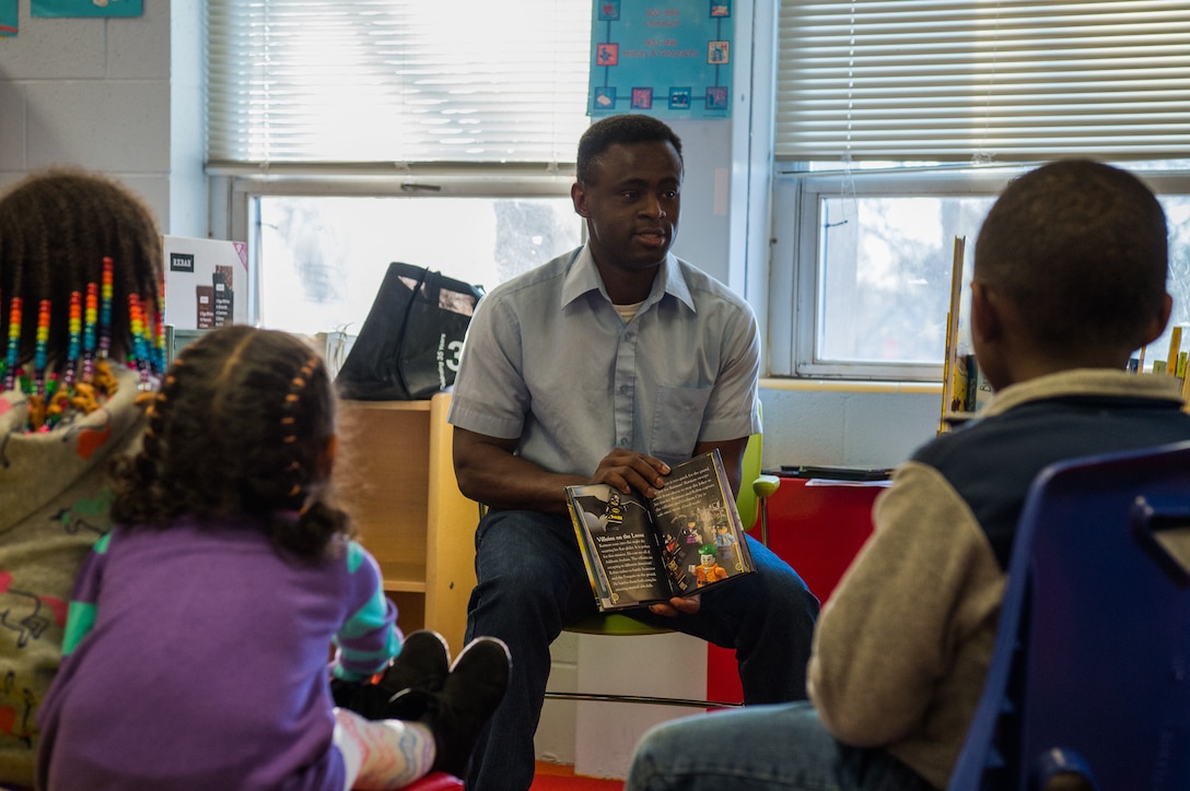 U.S. Army Staff Sgt. Venance Akissi, Charlie Company, 1st Battalion, 210th Aviation Regiment, 128th Avn. Brigade instructor, reads a book to children at the Groninger Library at Joint Base Langley-Eustis, Virginia, Jan. 26, 2018.