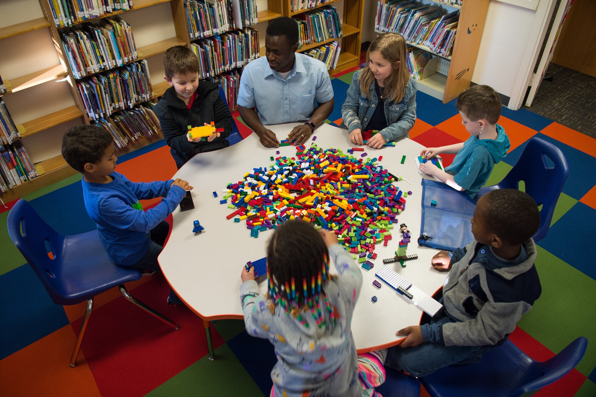 U.S. Army Staff Sgt. Venance Akissi, Charlie Company, 1st Battalion, 210th Aviation Regiment, 128th Avn.  Brigade instructor, plays with Legos with children at the Groninger Library at Joint Base Langley-Eustis, Virginia, Jan. 26, 2018.