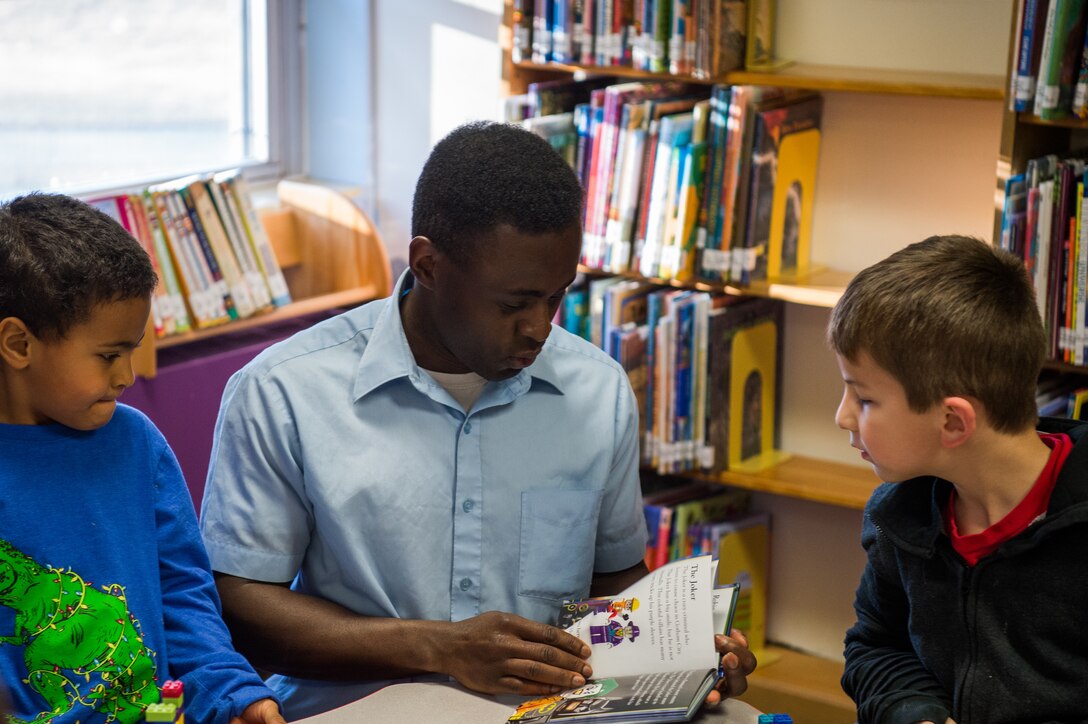 U.S. Army Staff Sgt. Venance Akissi, Charlie Company, 1st Battalion, 210th Aviation Regiment, 128th Avn. Brigade instructor, reads a book to children at the Groninger Library at Joint Base Langley-Eustis, Virginia, Jan. 26, 2018.