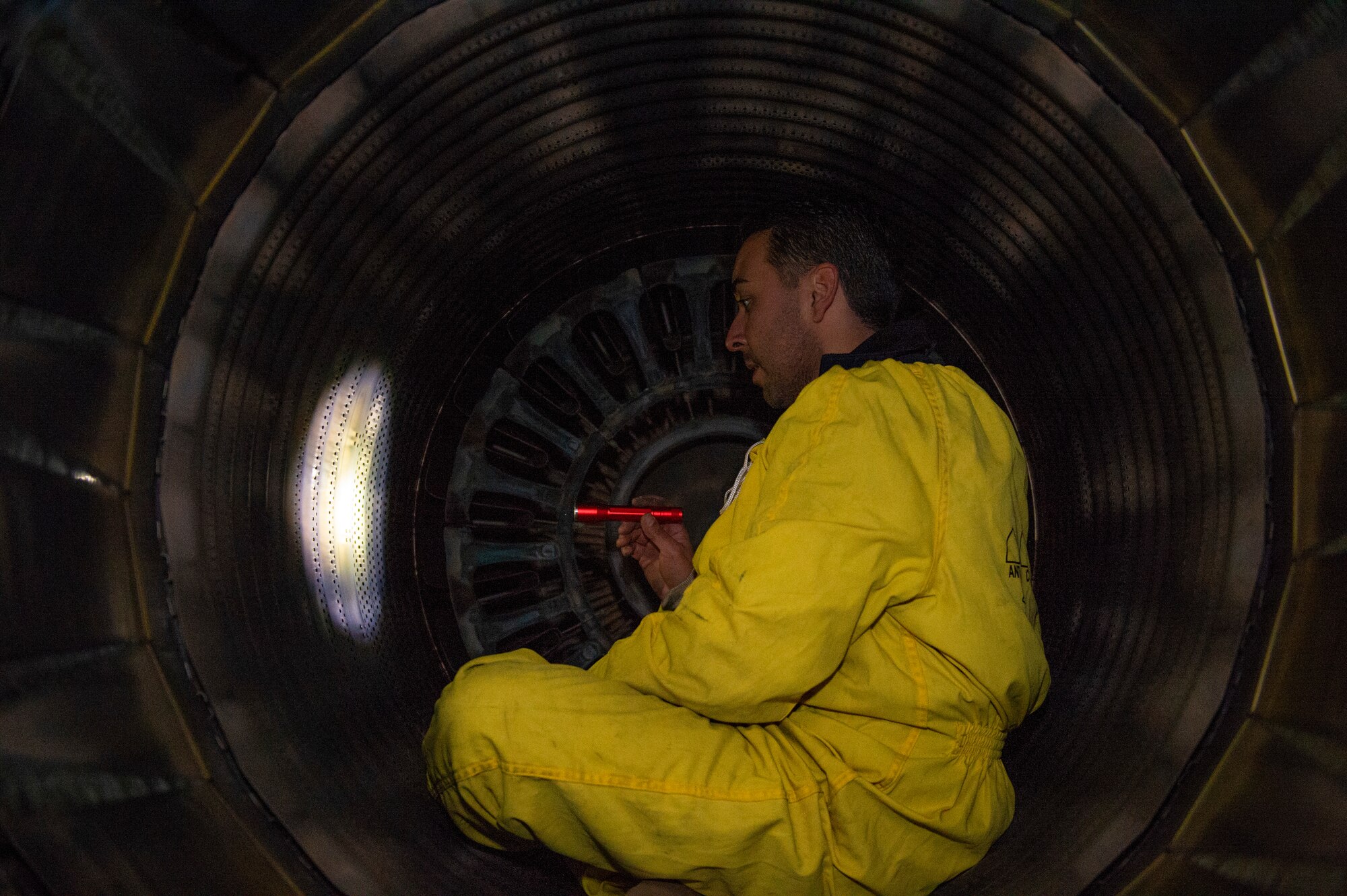 Load crews communicate through hand signals while loading pods, tanks, and missiles.