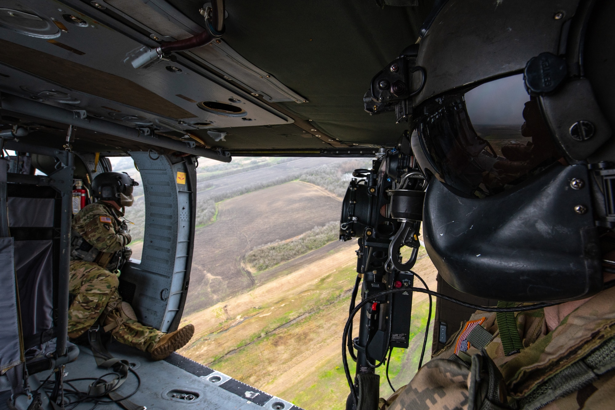 Sergeant First Class Dion Cortez, left, and Staff Sergeant Charles Jackson look out the doors of a UH-60 Black Hawk helicopter during a sling load training event at Martindale Army Airfield, San Antonio, TX, Feb. 1, 2019.