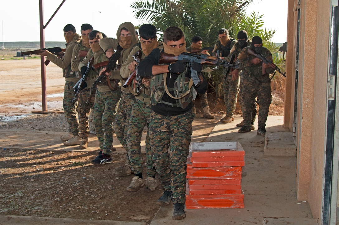 Two lines of armed soldiers in camouflage enter a building.