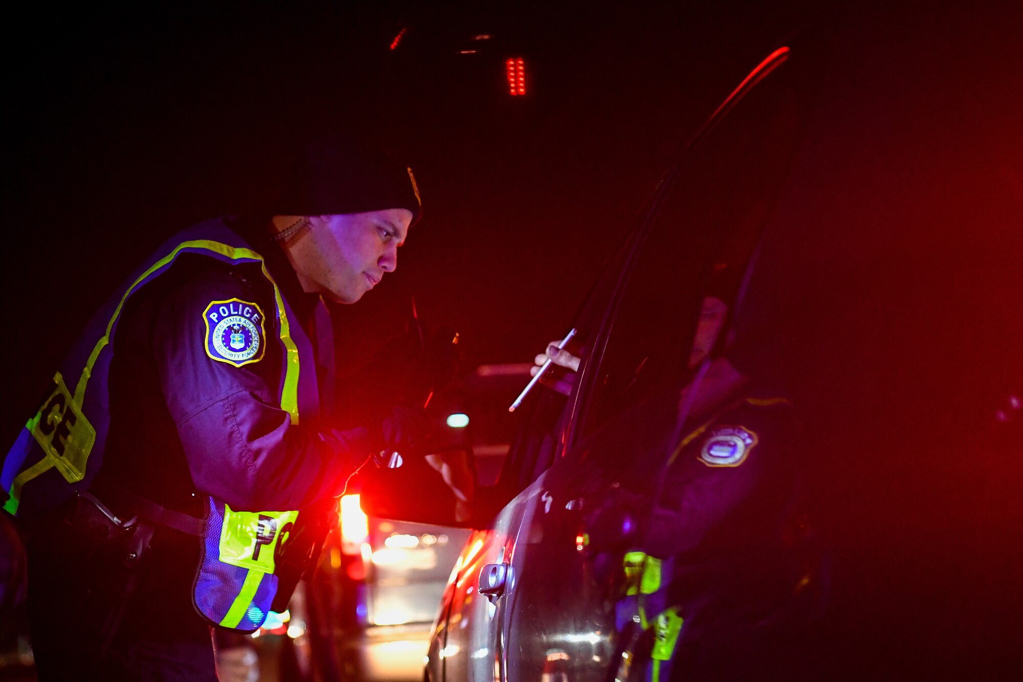 Shaun Turner, 628th Security Forces Squadron patrolman, checks a driver’s insurance during a DUI checkpoint Feb. 3, 2019, at Joint Base Charleston, S.C.