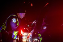 Shaun Turner, 628th Security Forces Squadron patrolman, checks a driver’s insurance during a DUI checkpoint Feb. 3, 2019, at Joint Base Charleston, S.C.