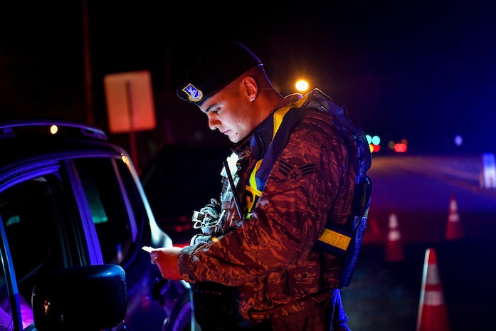 Senior Airman Joe Serna, 628th Security Forces Squadron patrolman, checks a driver’s insurance during a DUI checkpoint Feb. 3, 2019, at Joint Base Charleston, S.C.