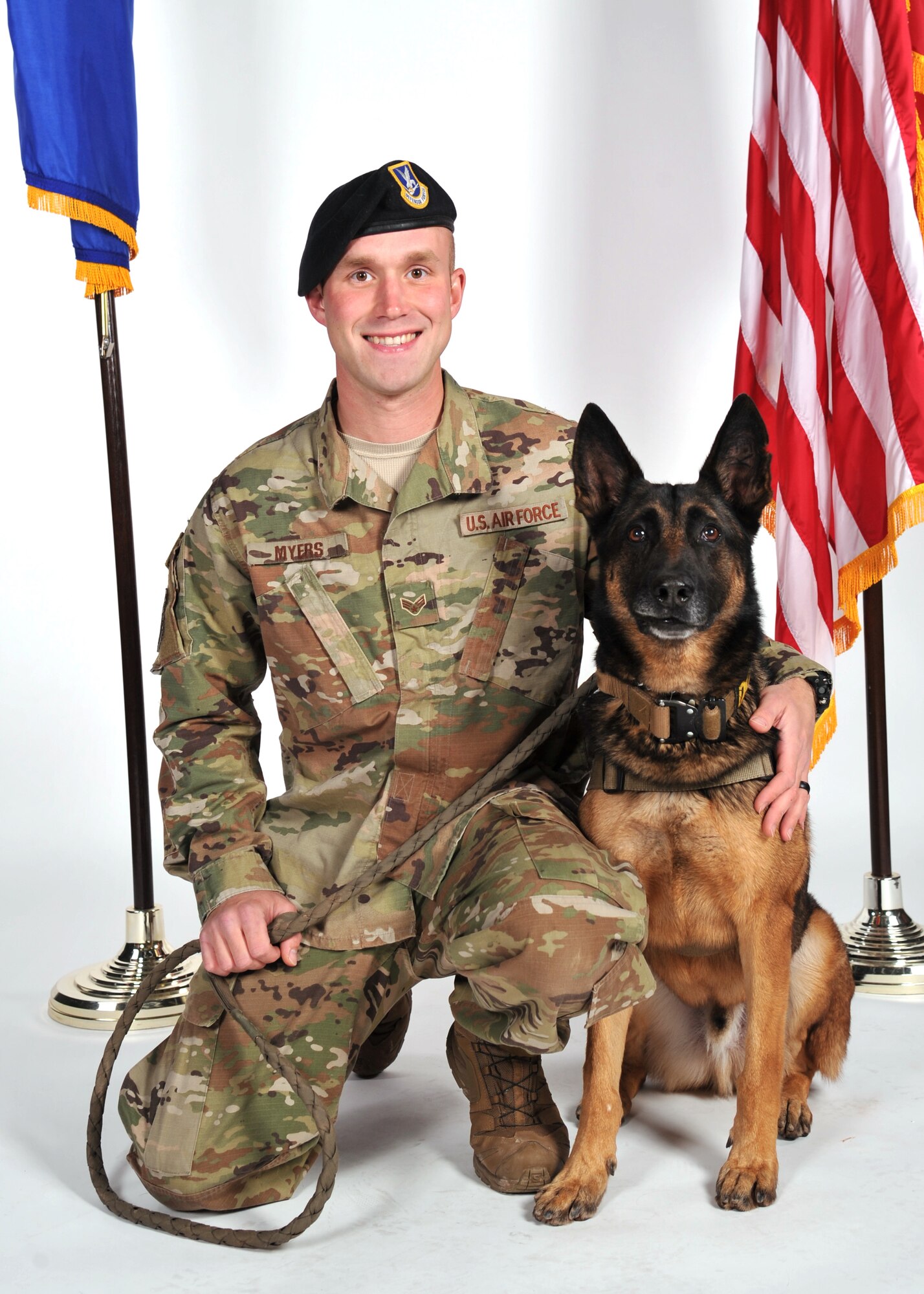 U.S. Air Force Senior Airman Shane Myers, 17th Security Forces Squadron military working dog handler, poses with Hugo, his K-9 partner, for a photo at the photo studio on Goodfellow Air Force Base, Texas, Jan. 8, 2019. Myers and Hugo have been training together since Myers arrived on Goodfellow in Oct. 2018. (U.S. Air Force photo by Senior Airman Seraiah Hines/Released)