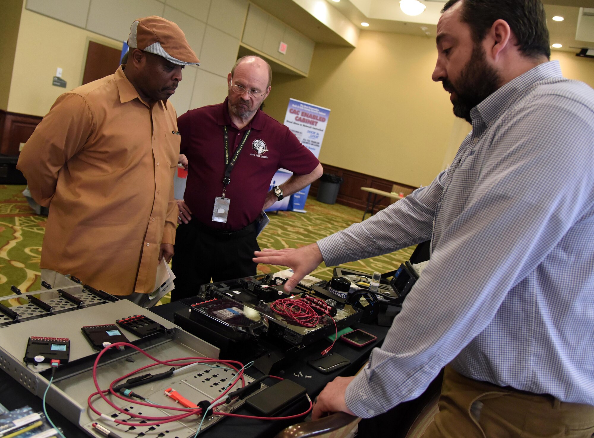 Derek Benson, Corning Optical Communications LLC sales engineer, provides an equipment brief to William Scott, 338th Training Squadron instructor supervisor, and Michael Clark, 338th TRS resource advisor, during the Annual Keesler Air Force Base Tech Expo inside the Bay Breeze Event Center at Keesler Air Force Base, Mississippi, Feb. 5, 2019. The expo was hosted by the 81st Communications Squadron and was free to all Defense Department, government and contractor personnel with base access. U.S. Air Force Maj. Jon Drummond, 81st CS commander, said events like this allows us to see the local vendors' newest technologies and find opportunities to branch that technology with Keesler's training mission. The event was held to introduce military members to the latest in technological advancements to bolster the Air Force's capabilities in national defense. (U.S. Air Force photo by Kemberly Groue)