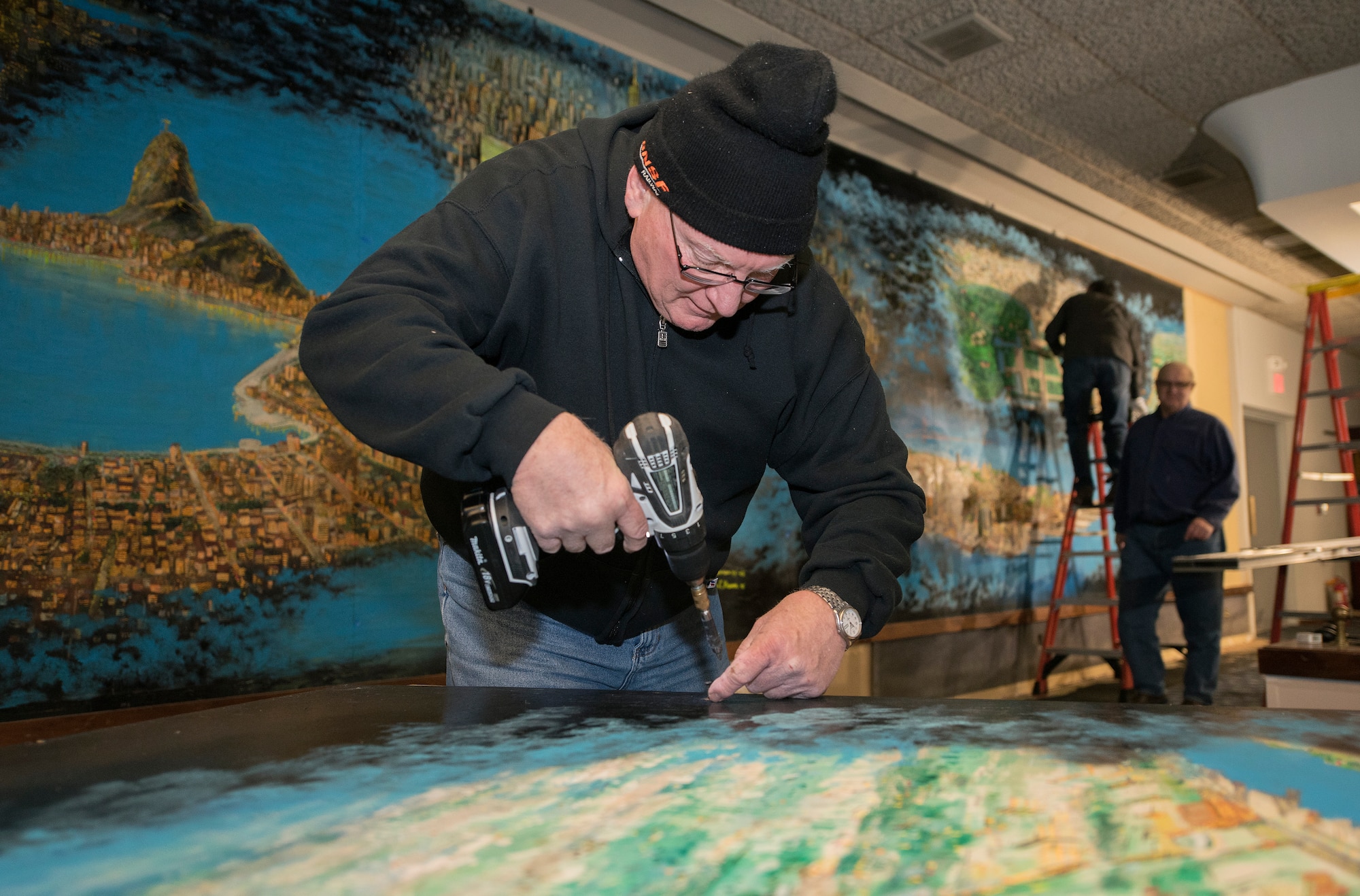 Volunteers from the Strategic Air Command Museum remove a 40-foot mural from the Global Lounge Jan. 29, 2019, at Offutt Air Force Base, Nebraska. (U.S. Air Force photo by Delanie Stafford)