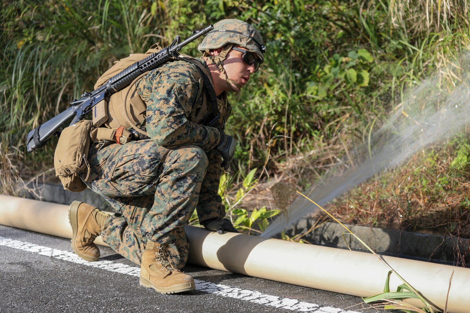Lance Cpl. Daniel D. Cruz examines a hole in a fuel hose on Jan. 28, 2019 at Central Training Area, Camp Hansen, Okinawa, Japan. Marines with 2nd Platoon, Bulk Fuel Company, 9th Engineer Support Battalion, 3rd Marine Logistics Group patrol fuel lines to ensure the integrity of the hose is compromised. Bulk Fuel Specialists assembled fuel sites across the CTA to enhance their training and readiness within a harsh environment. The Marines set up and maintained their bulk fuel equipment during a week-long training evolution. Cruz, a native of Tulare, California, is a bulk fuel specialist with 2nd Plt., Bulk Fuel Co., 9th ESB, 3rd MLG. (U.S. Marine Corps photo by Lance Cpl. Armando Elizalde)