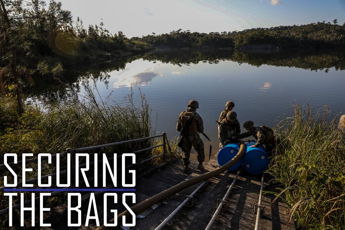 Marines with 2nd Platoon, Bulk Fuel Company, 9th Engineer Support Battalion, 3rd Marine Logistics Group, tie a suction hose to barrels on Jan. 28, 2019 at Central Training Area, Camp Hansen, Okinawa, Japan. Bulk fuel specialists assembled several fuel sites across the CTA to enhance their training and readiness within a harsh environment. The Marines set up and maintained their bulk fuel equipment during a week-long training evolution. (U.S. Marine Corps photo by Lance Cpl. Armando Elizalde)
