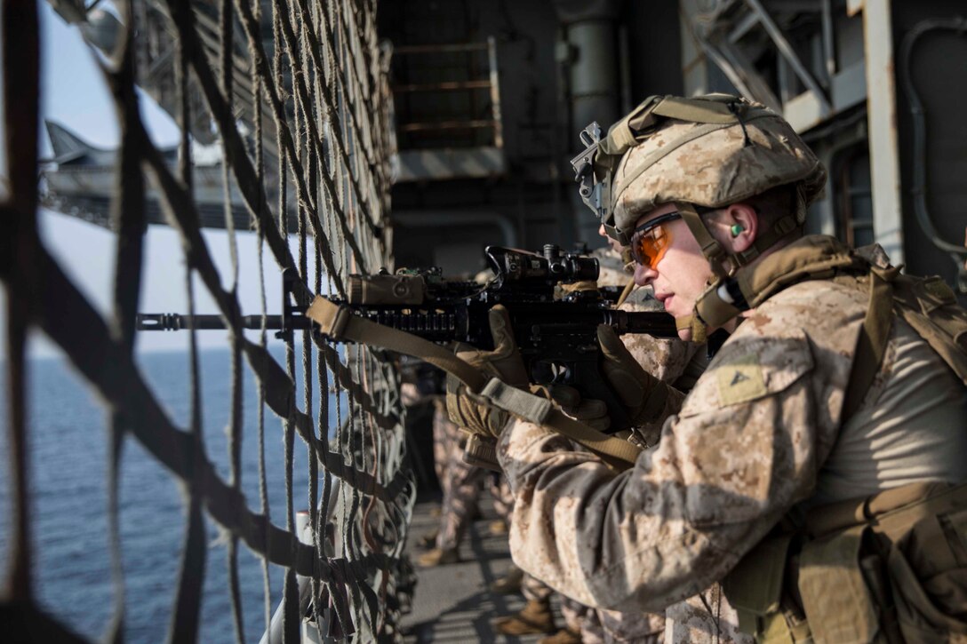 U.S. Marine Corps Lance Cpl. Kenneth Barrett, a machine gunner with the 22nd Marine Expeditionary Unit, sights in during a deck shoot as a part of Tactical Recovery of Aircraft and Personnel training aboard the USS Kearsarge. Marines with Alpha Company, 1st Battalion, 2nd Marine Regiment conducted TRAP training as preparation for entering combative areas and retrieving or destroying sensitive material as well as recovering personnel. Marines and Sailors with the 22nd MEU and Kearsarge Amphibious Ready Group are deployed to the 5th Fleet area of operations in support of naval operations to ensure maritime stability and security in the Central Region, connecting the Mediterranean and the Pacific through the western Indian Ocean and three strategic choke points.