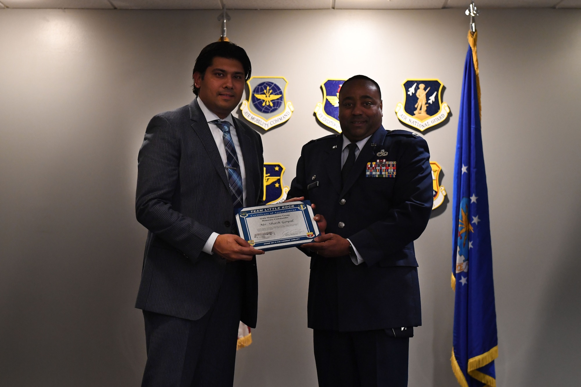 Two men stand and hold a certificate.