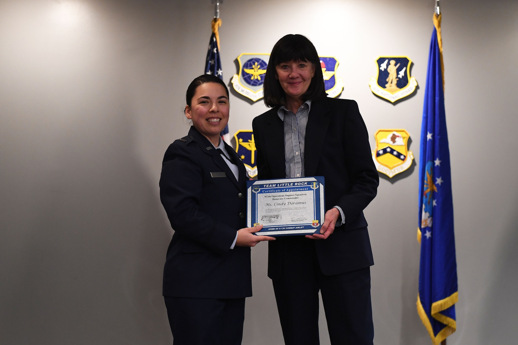Two women stand together holding a certificate.
