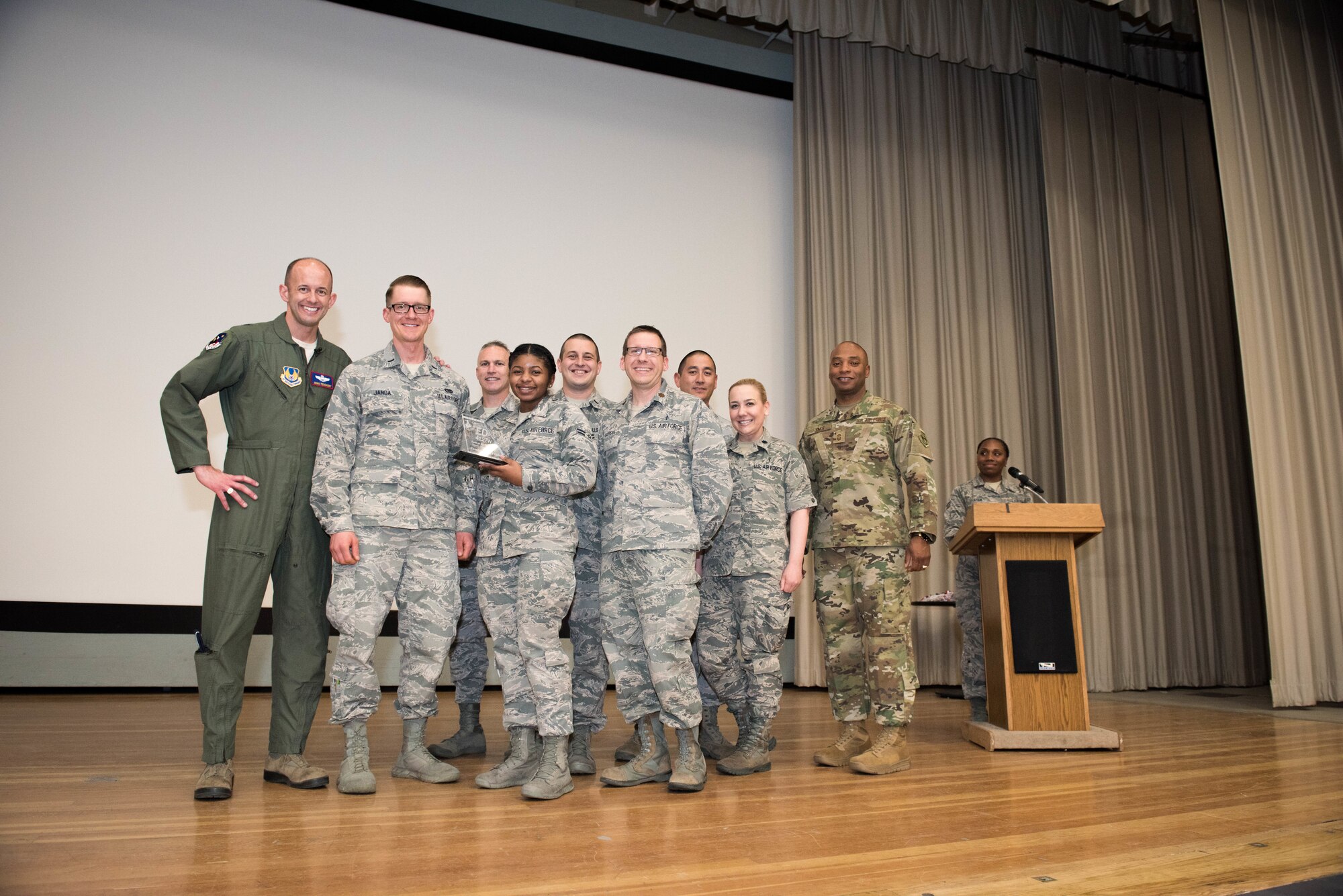 Brig. Gen. E. John Teicert, 412th Test Wing commander (left), poses for a photo with the 412th Medical Group's Family Health Flight and Chief Master Sgt. Roosevelt Jones, 412th TW command chief (right), at the 2018 412th TW 4th Quarter Awards Ceremony held in the base theater Jan. 31, 2019. (U.S. Air Force photo by Joe Jones)