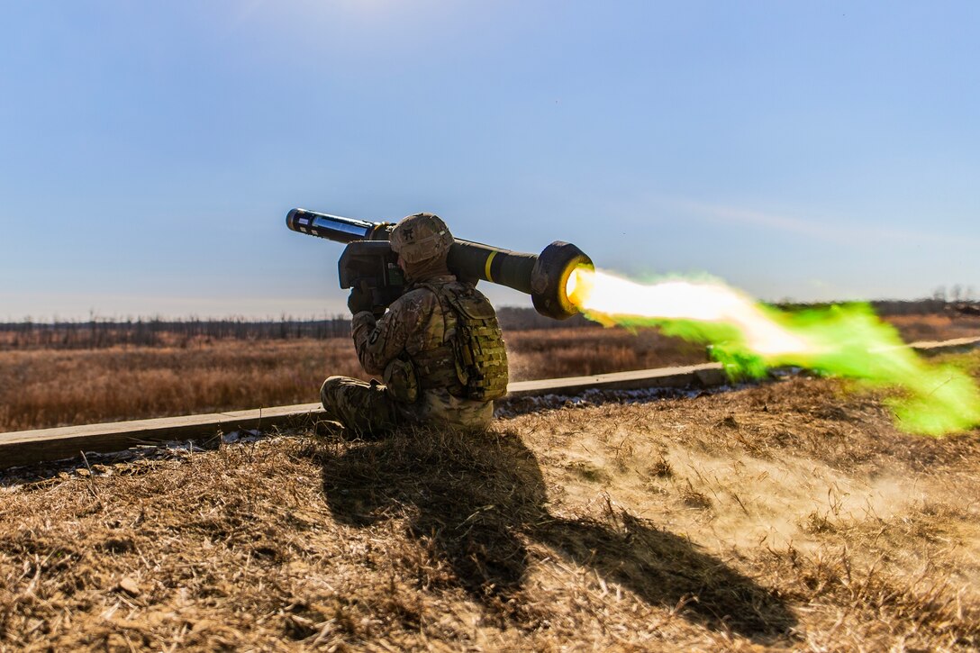 A soldier fires a missile from his shoulder.