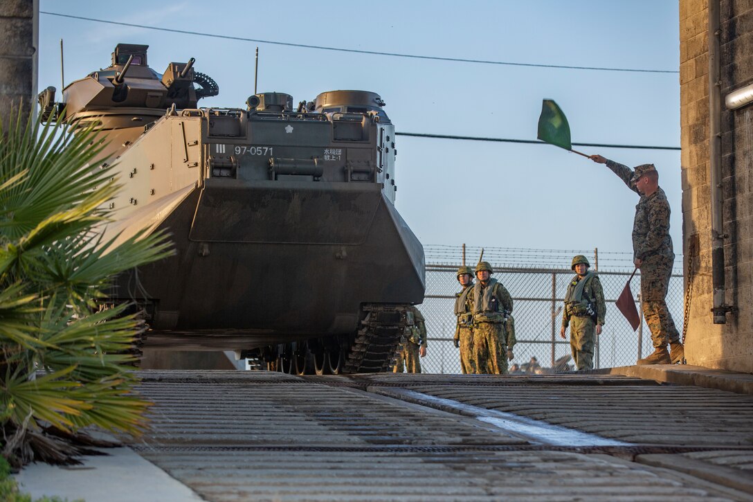 A U.S. Marine gives the Japan Ground Self-Defense Force Soldiers with 1st Amphibious Rapid Deployment Regiment, the go ahead for the assault amphibious vehicles to enter the water and travel to the USS Somerset (LPD 25) during Iron Fist 2019, Jan. 30 on U.S. Marine Corps Base Camp Pendleton, CA.