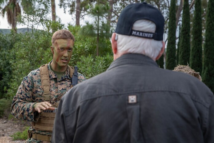 U.S. Marine Corps Sgt. Patrick Butler, left, a machine gunner with 2nd Battalion, 4th Marine Regiment, 1st Marine Division (MARDIV), discusses modern military tactics with a Marine Corps veteran during the week of 1st MARDIV's 78th anniversary at Marine Corps Base Camp Pendleton, California, Jan. 29, 2019.