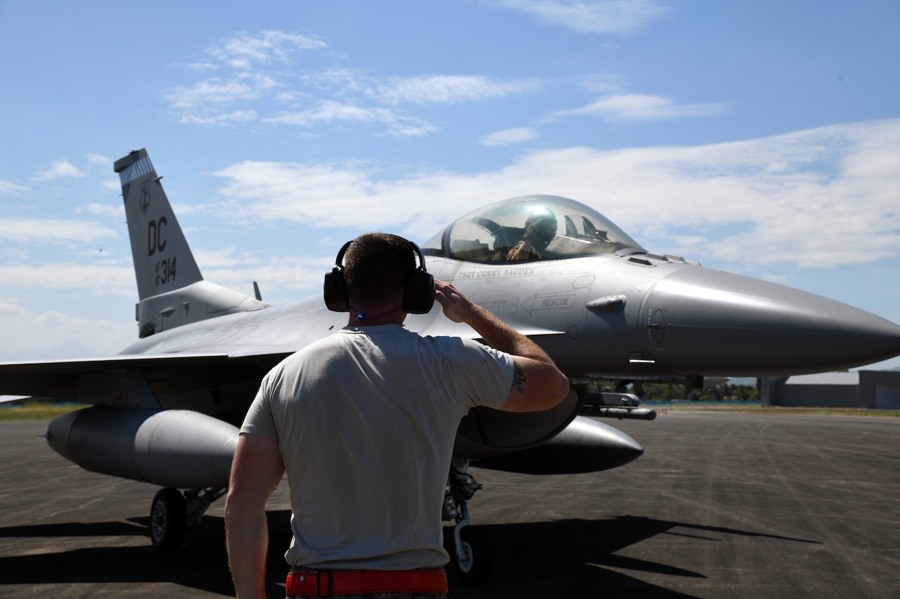 Person salutes pilot in jet
