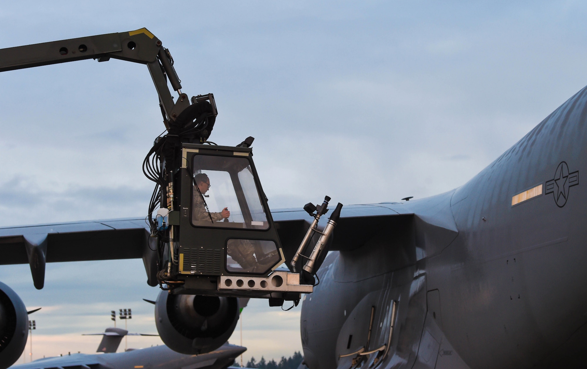 Senior Airman Dakota Crites, 62nd Aircraft Maintenance integrated flight control systems specialist, brings the bucket of a deicing truck down to the ground after deicing a C-17 Globemaster III at Joint Base Lewis-McChord, Wash., Jan. 16, 2019. Crites and other 62nd AMXS Airmen sprayed deicing liquid on the wings and tail of the C-17 to remove snow and ice from the aircraft and make it safe to fly. (U.S. Air Force photo by Senior Airman Tryphena Mayhugh)
