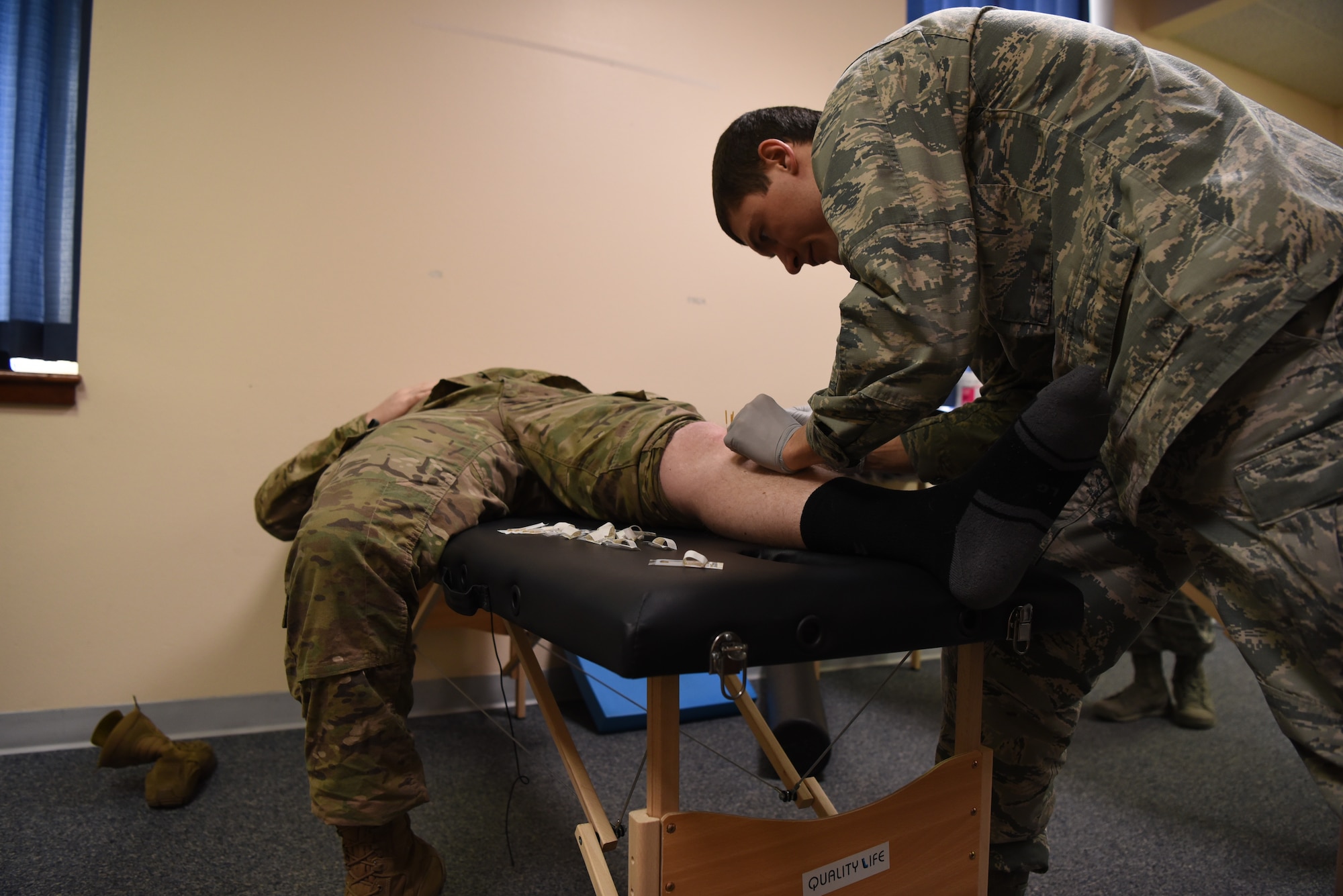 Captain Eric Walter, 90th Medical Operations Squadron physical therapy flight commander, performs dry needling on a 890th Missile Security Forces Squadron defender during a weekly squadron visit Feb. 4, 2019, at F.E. Warren Air Force Base, Wyo. The 90th MDOS PT team created a physical therapy program to provide better access to care, working around the unique schedules of defenders. (U.S. Air Force photo by Senior Airman Abbigayle Williams)