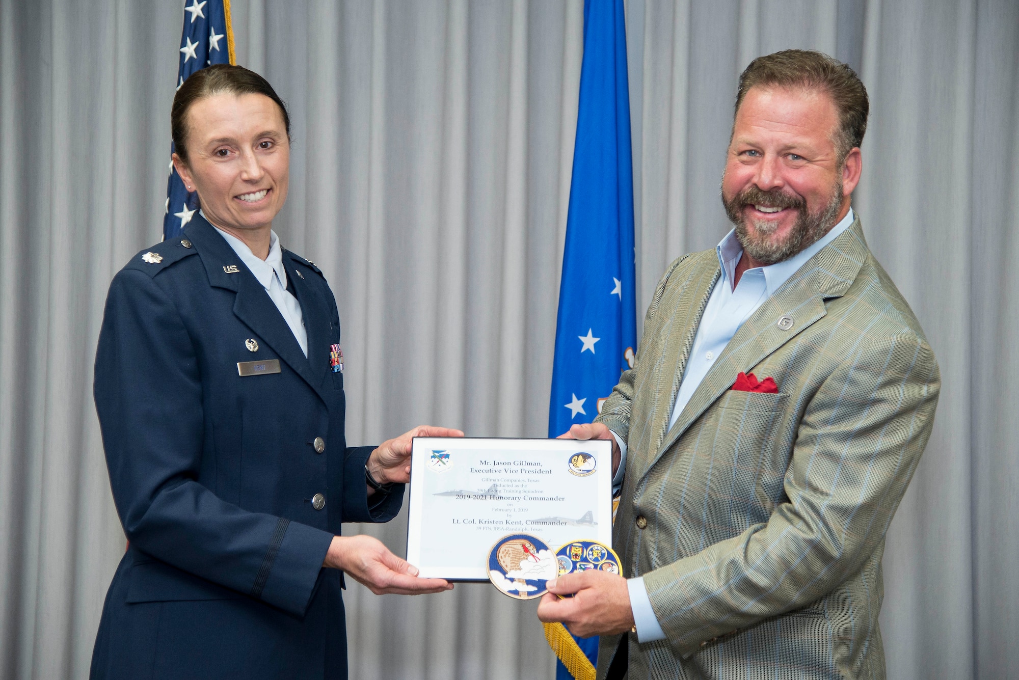 39th Flying Training Squadron Commander Lt. Col. Kristen Kent presents the induction certificate to the squadron’s new honorary commander, Gillman Companies Executive Vice President Jason Gillman, during the Feb. 1 honorary commander induction ceremony held at Joint Base San Antonio-Randolph, Texas. (U.S. Air Force photo by Sean Worrell)