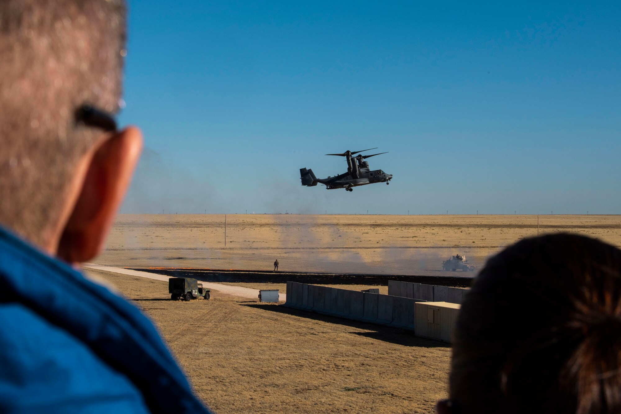 A group of people watch an aircraft land.