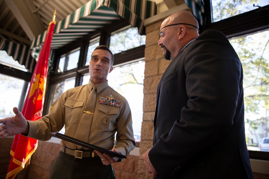 Col. Charles Dockery, commanding officer Marine Corps Air Station Miramar, left, presents an award to Ret. GySgt. Nicholas Popaditch, former Marine and motivational speaker, right, during the National Prayer Breakfast at MCAS Miramar, Calif.,  Feb. 7. The National Prayer Breakfast is a yearly event that is designed to be a forum for professionals in the political, social and business worlds to assemble and build relationships. (U.S. Marine Corps photo by Cpl. Preston Hightower)