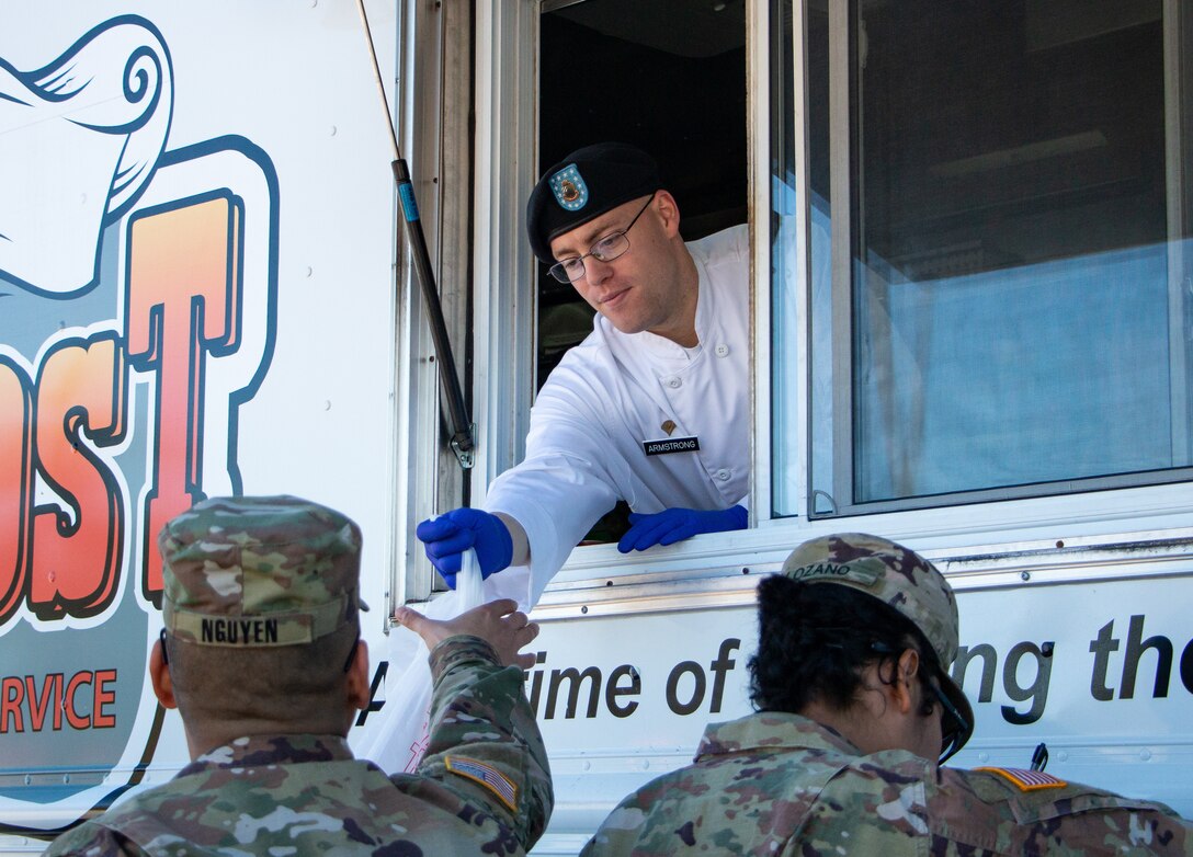 Spc. David Armstrong, Culinary Specialist for 1st Battalion, 41st Field Artillery Regiment, 1st Armored Brigade Combat Team, passes out orders at the Outpost Food Truck, Jan. 22, at Fort Stewart, Ga. The food truck offers a variety of food from burgers and fries to tacos and salads, allowing Soldiers a chance to eat affordable meals without having to travel far from work or home.