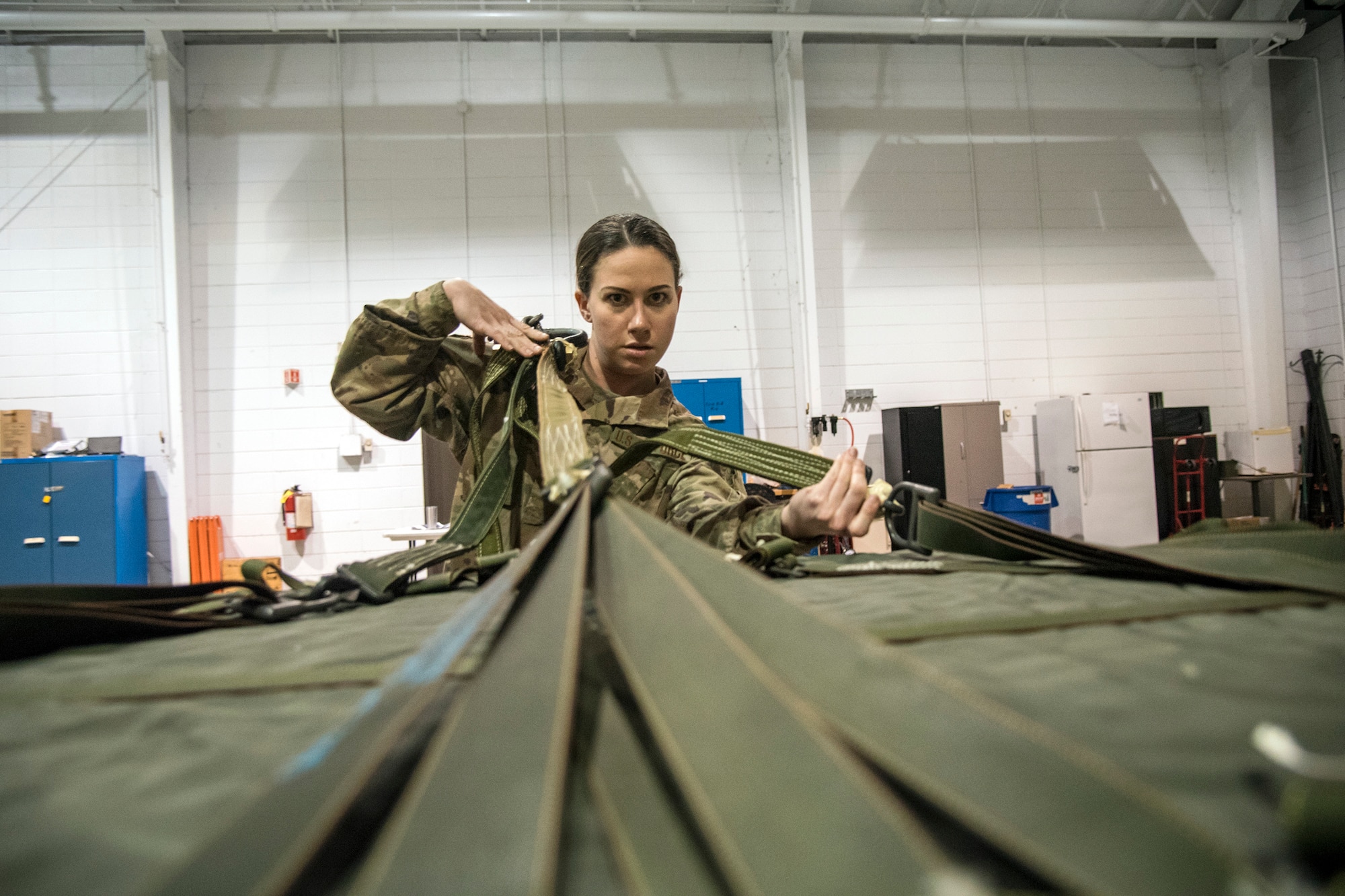 2nd Lt. Aurora Harting, 824 Base Defense Squadron S3 flight commander, inspects the Lateral strap on an 822 cargo bag during an Army Air Assault Assessment (AAA), Jan. 29, 2019, at Moody Air Force Base, Ga. Airmen were required to identify structural deficiencies on the sling load portion of the cargo bag as part of an overall assessment to determine their readiness to attend Army Air Assault School. (U.S. Air Force photo by Airman First Class Eugene Oliver)