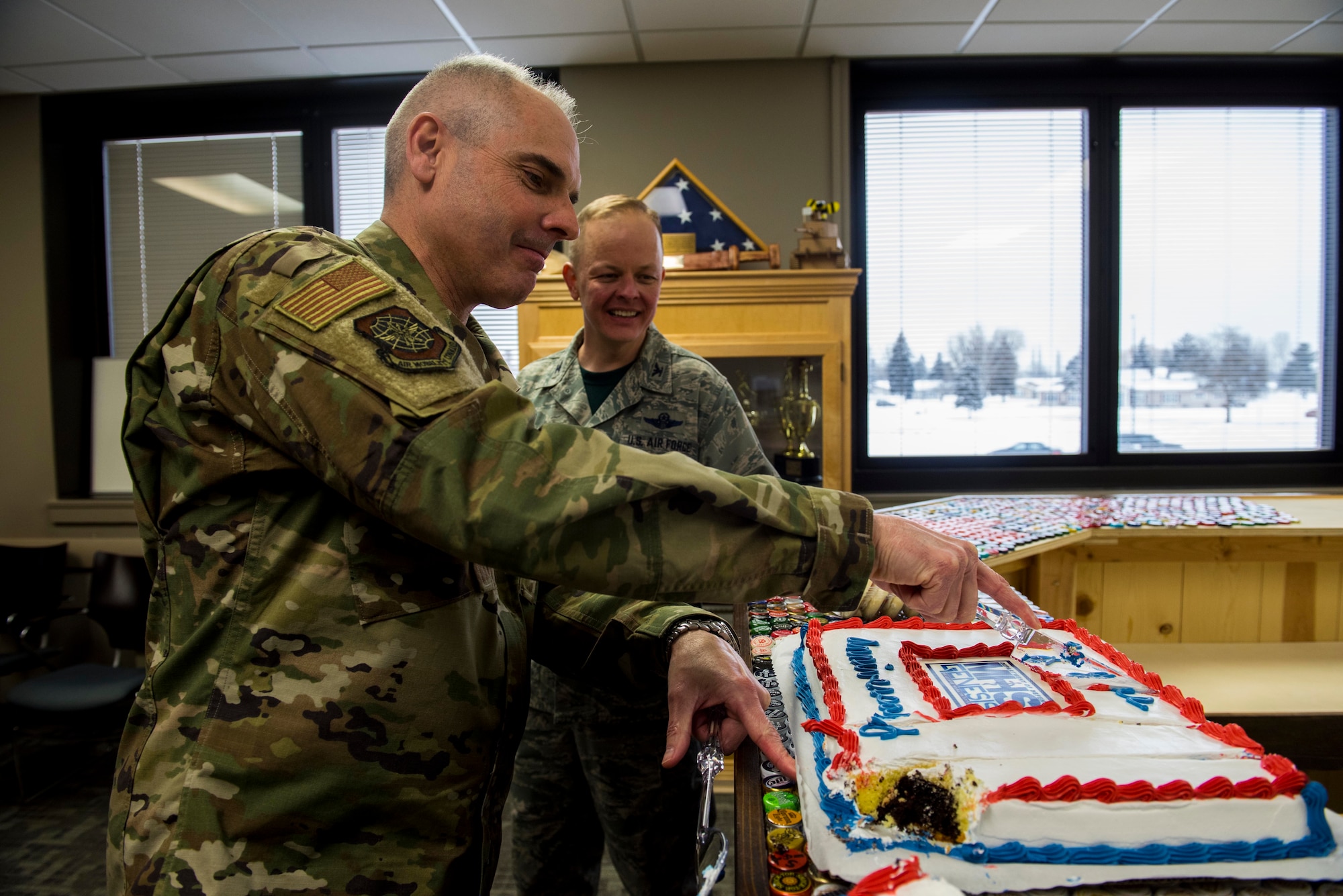 Col. Ronald Merchant, Air Mobility Command medical support division chief, and Col. Derek Salmi, 92nd Air Refueling Wing commander, cut a cke in celebration for the second year anniversary of Military Health System Genesis' arrival to the 92nd Medical Group at Fairchild Air Force Base, Washington, Feb. 8, 2019.  Fairchild was selected to be the pilot base for the Genesis due to its location, patient load, a record of excellence and enthusiasm to take on the project. (U.S. Air Force photo/Airman 1st Class Lawrence Sena)